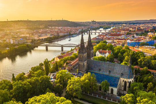 A stunning aerial view of Vy&scaron;ehrad Castle and the Church of St. Peter and Paul in Prague, Czech Republic, at sunset, showcasing Gothic architecture and the historic fortress above the Vltava River