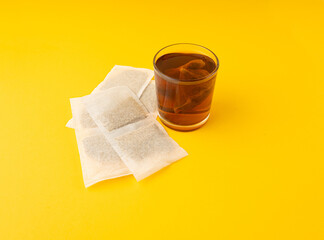 Herbal tea sachet in glass, hot water with chamomile and Hypericum or St. John's wort teabag