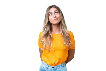 Young Uruguayan woman over isolated background and looking up