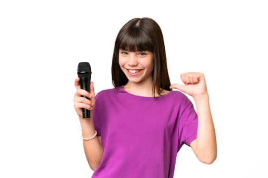 Little singer girl picking up a microphone over isolated background proud and self-satisfied