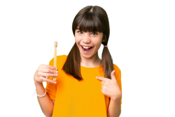 Little caucasian girl brushing teeth over isolated background with surprise facial expression