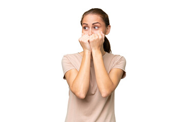 Young caucasian woman over isolated background nervous and scared putting hands to mouth