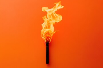 Burning matchstick stands vertically against a bright orange background