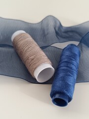 
Beige and blue threads with a blue ribbon.


