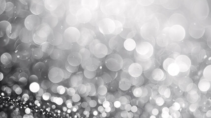 Blurred abstract background with shiny silver bokeh, featuring white bokeh elements against a grey backdrop.