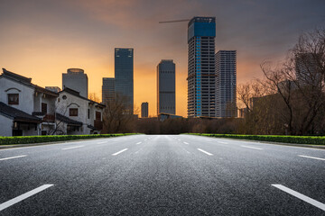 Urban Landscape: A Modern Road Leading into a Sunset City Skyline