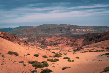 Fototapeta premium Interior arid desert volcanic lonely wasteland in Caldera of Tenerife with dark cliffs, valleys and mountains on horizon during summer hot day, whjen hiking GR131 trail. Canary Islands, Spain.