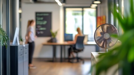 Modern office scene with workers and fan.
