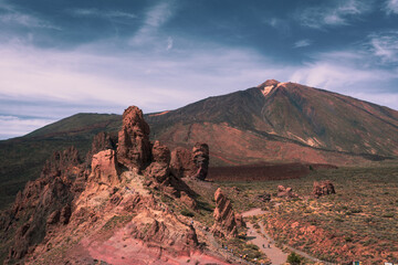 Panorama view over volcanic rock formation called La Catedral with epic mountains on the background with summit of Pico del Teide during hot summer day on Tenerife nature park, Canary, Spain
