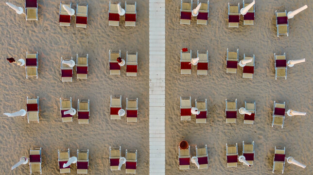 Top down view of closed umbrellas in the evening in summer at the beach of Marina di Ostuni, Puglia, Italy