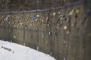 Dozens of padlocks locked onto an old rusted steel fence.