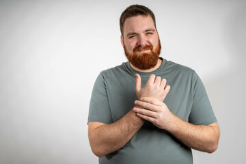 Man touching wrist of hand feeling pain on gray background. Tunnel syndrome, neuralgia, pinched...