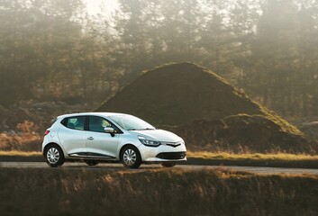 Fototapeta premium Small hatchback driving through serene countryside