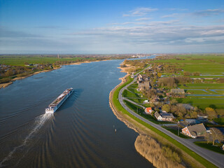 Small cruise ship sailing on a Dutch river seen from above