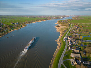 Small cruise ship sailing on a Dutch river seen from above