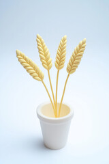 Yellow decorative leaves in white pot against light background