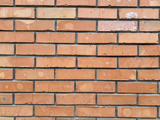 Brick wall texture showcasing varying shades and patterns from sunlight exposure and wear over time in an urban setting