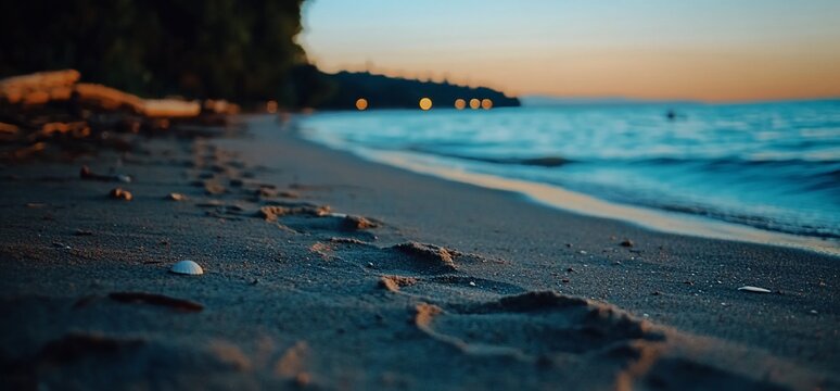 Footprints on the beach at twilight, inviting seaside serenity