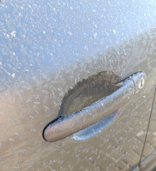 Frozen car handle covered in frost