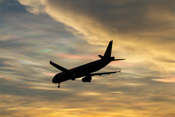 An Commercial Airplane Landing At Sunset. 