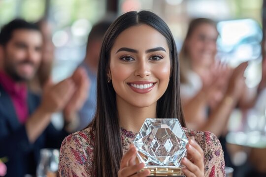 A woman holds a trophy as she stands among a group of people, perfect for celebrating achievements and recognizing success