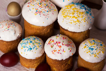 Easter bread with icing and colourful sprinkles on a table with Easter eggs, Food for Easter.