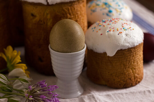 Olive Easter egg and pascaline bread on a table with flowers. Easter concept, background.