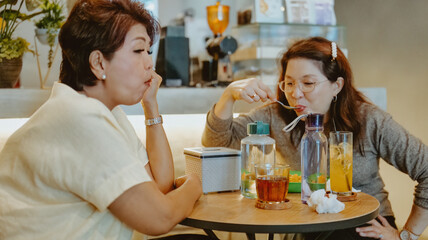 Two women are eating and chatting in a cafe.