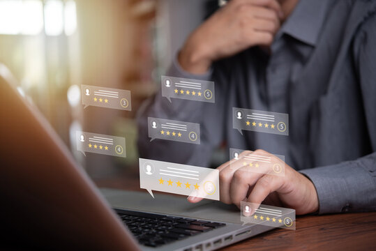 Businessman is giving online reviews feedback on laptop with digital review score display. Concept of customer opinion, satisfaction and online customer service ranking.