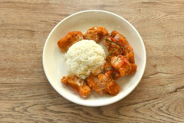 spicy stir fried pangasius fish with curry and dressing coconut milk eat couple plain rice on plate