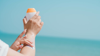 Health skin care, Young woman applying sunscreen cream on body, Sun Protection. Female hands with sun protection cream on sky background. Skin body cream moisturizing lotion