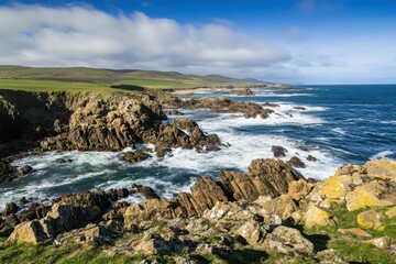 Obraz premium Rugged Coastal Landscape with Rocky Cliffs and Ocean Waves under Blue Sky