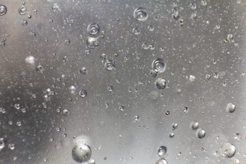 Air bubbles fluwing in a light beige liquid.