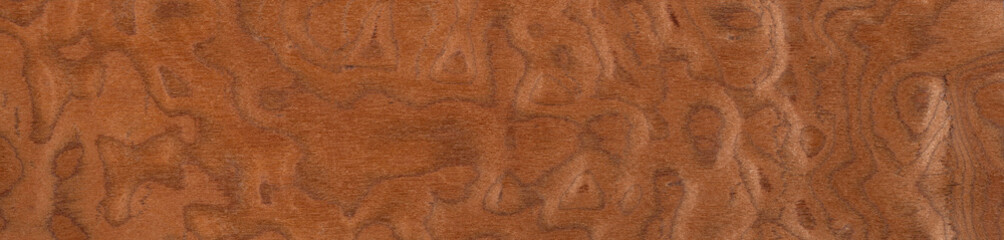 Swirls of auburn and cinnamon on a polished veneer wood surface