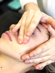 Spa facial massage. A young European girl gets a face, neck and head massage. Cosmetic care, face washing.