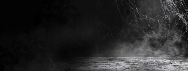 Dark empty space background with concrete, smoke, and cobweb details, suitable for Halloween themes.