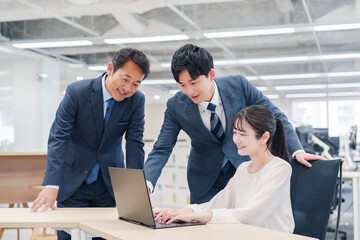 オフィスのデスクで打ち合わせをする男女のビジネスパーソン