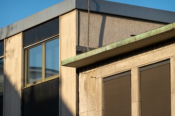 Sunlight reflecting on modern building facade with copper gutter