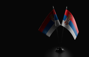 Small national flags of the Serbia on a black background