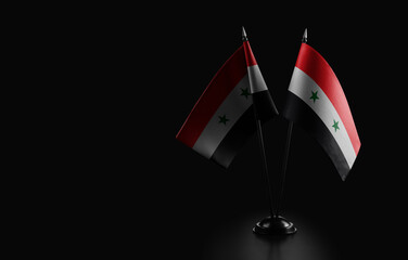 Small national flags of the Syria on a black background