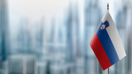 Small flags of the Slovenia on an abstract blurry background