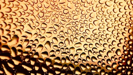 Close-up of water drops on metal surface in high resolution showing condensation of water droplets on metal surface. Intricate patterns and different sized water droplets create a beautiful abstract