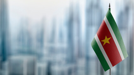 Small flags of the Suriname on an abstract blurry background
