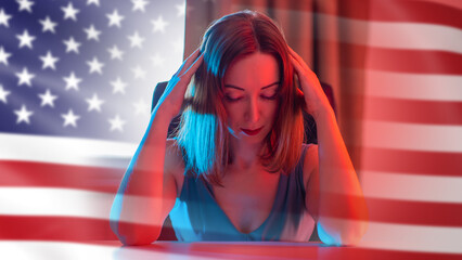 US businesswoman is upset. Woman investor sits clutching head. Depressed lady near American flag....