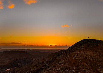 Mid aspect aerial distance panoramic image of volcanic mountains at sunrise near Corralejo and Lajares, Fuerteventura, Canary Islands, Spain