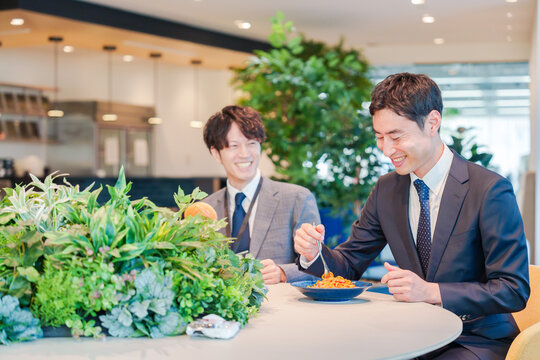 おしゃれなオフィスのカフェテリアでランチをするビジネスマン