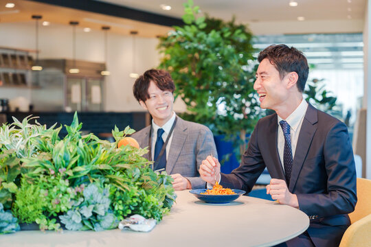 おしゃれなオフィスのカフェテリアでランチをするビジネスマン