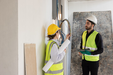 team electrical engineers or technicians is professionally inspecting the wiring and systems in the building. Check electrical equipment to meet safety standards. Use a tablet to check buildings.