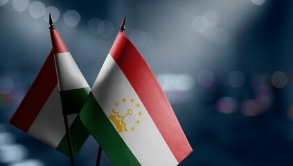 Small flags of the Tajikistan on an abstract blurry background