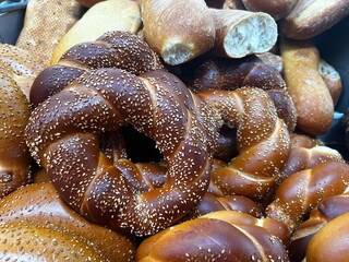 Sesame bagel, pretzel. Fresh baked goods on the farmer's market stand. Turkish Simit and Sticky Buns